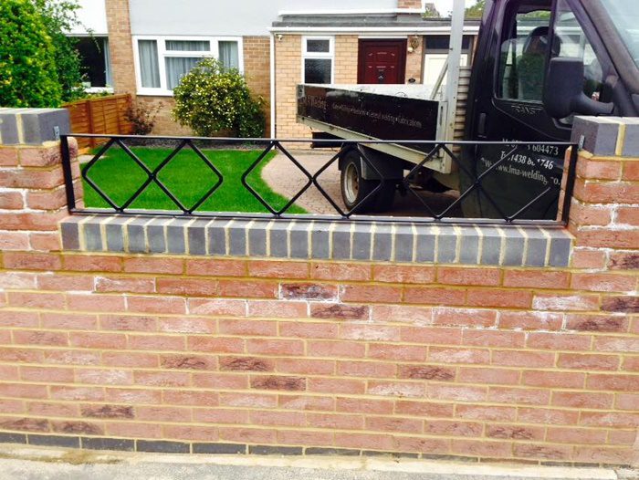 Garden wall with decorative steel railings